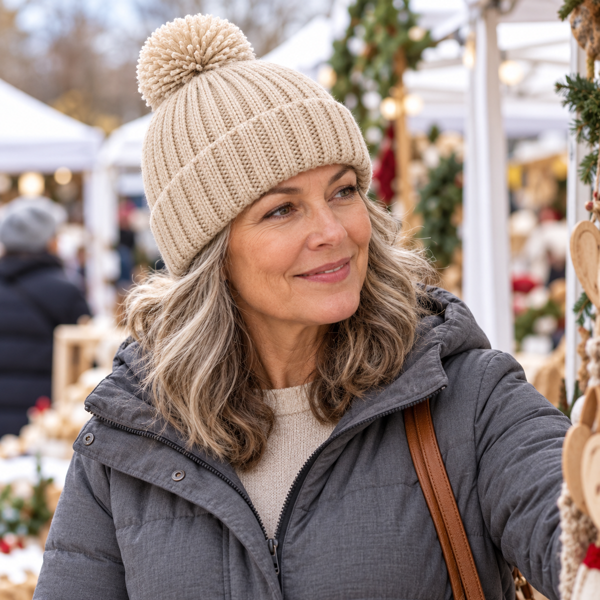 Oatmeal pom beanie worn at outdoor weekend market