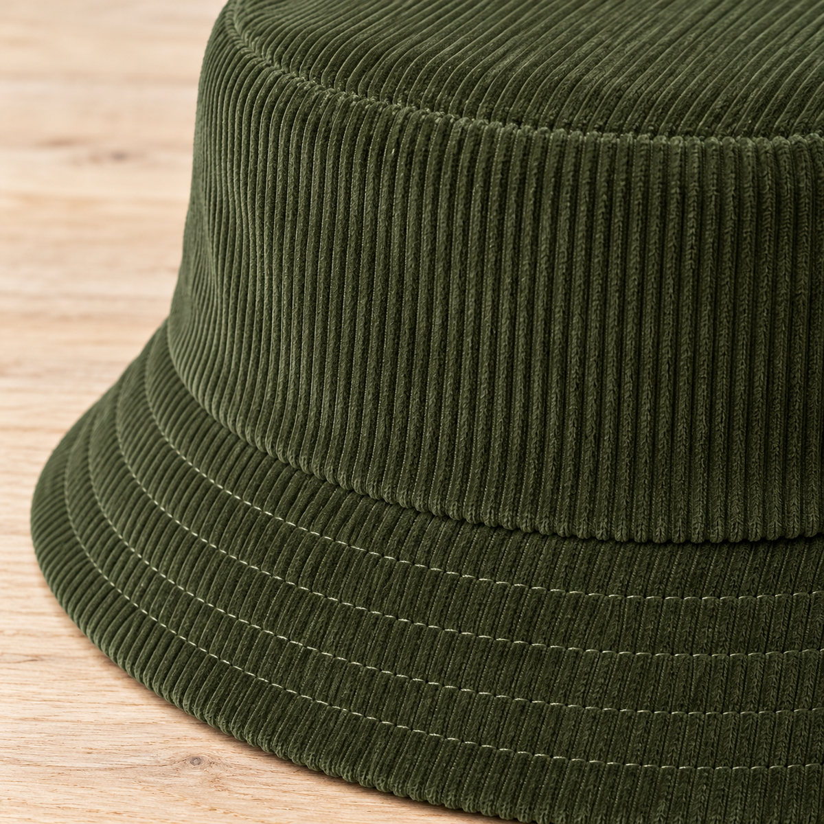 Close-up of olive corduroy ridges and stitched bucket hat brim